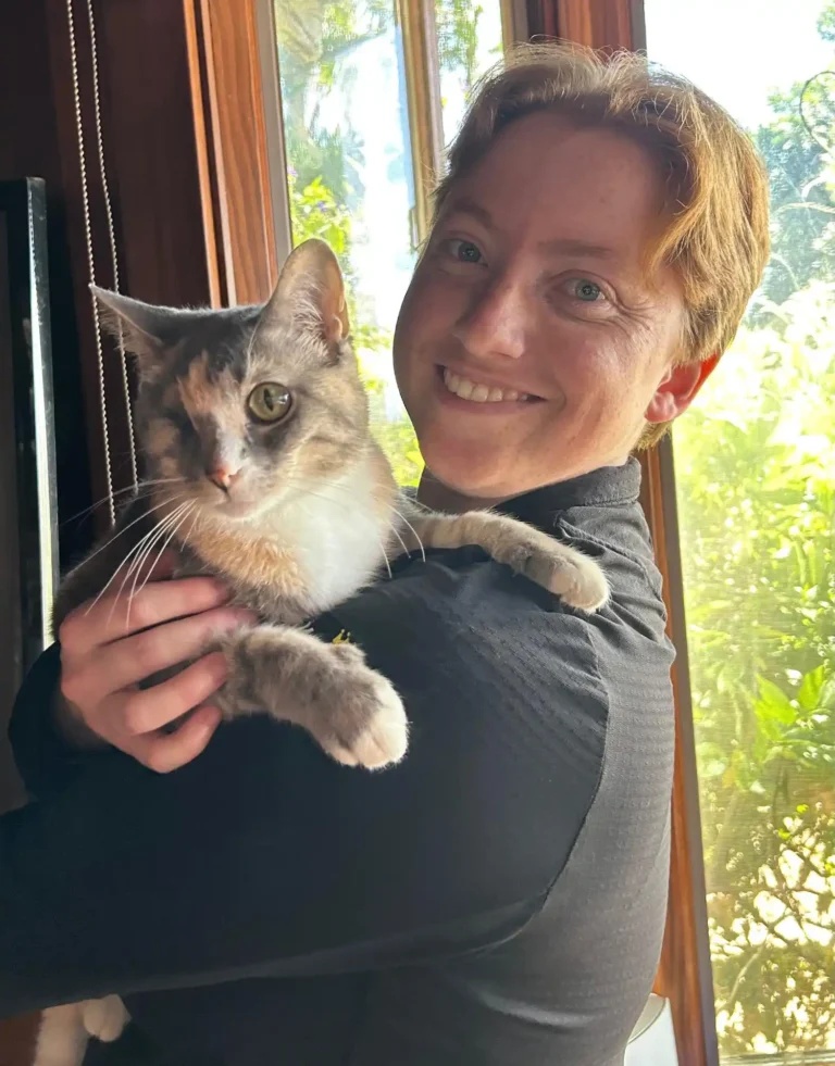 Catherine with her one of her cats on her shoulder.