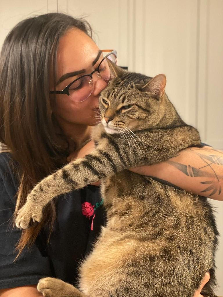 Taleaha, a Coco And Boo pet care specialist, seen holding and kissing one of her cats.